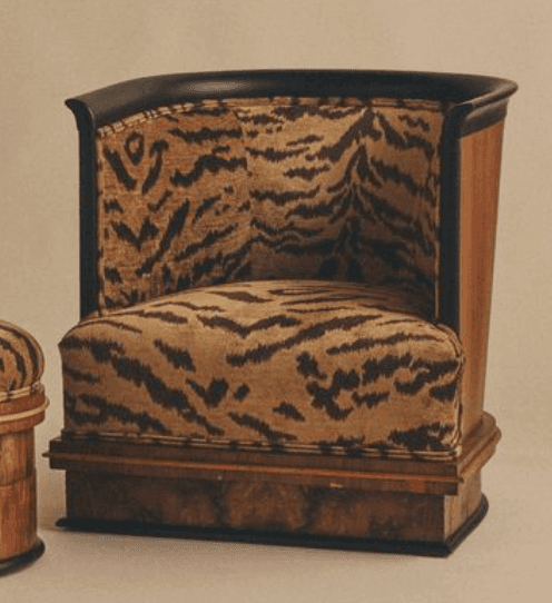 A barrel-shaped club chair upholstered in a striking tiger-stripe fabric, featuring a dark wood pane… — 3D model