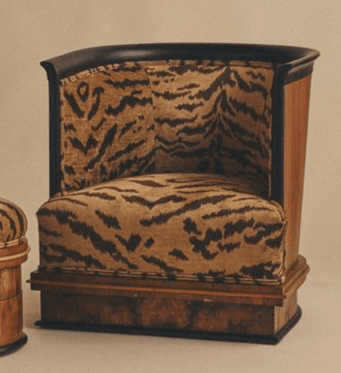 A barrel-shaped club chair upholstered in a striking tiger-stripe fabric, featuring a dark wood panel exterior with a sleek black trim. The base showcases a distinctive burled wood veneer. — 3D model
