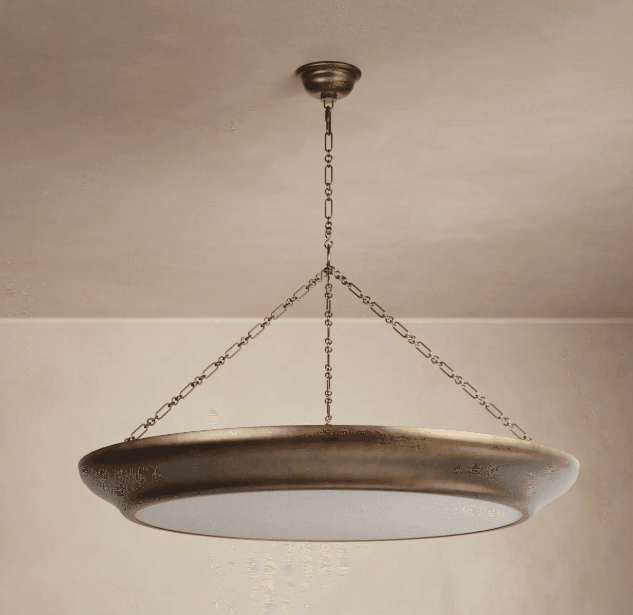 A brass-colored chandelier with a wide, shallow bowl-shaped fixture suspended from the ceiling by a decorative chain. The fixture has a smooth, metallic outer rim and a translucent white diffuser disc at the bottom, suggesting it is designed to cast ambient light. — 3D model