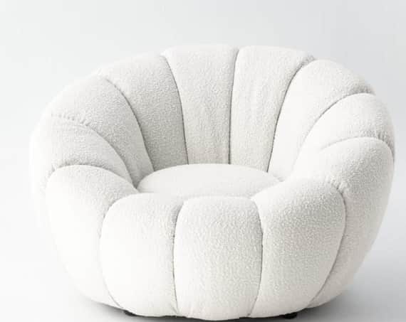 A low-profile, rounded lounge chair upholstered in a textured, off-white bouclé fabric. The chair fe… — 3D model