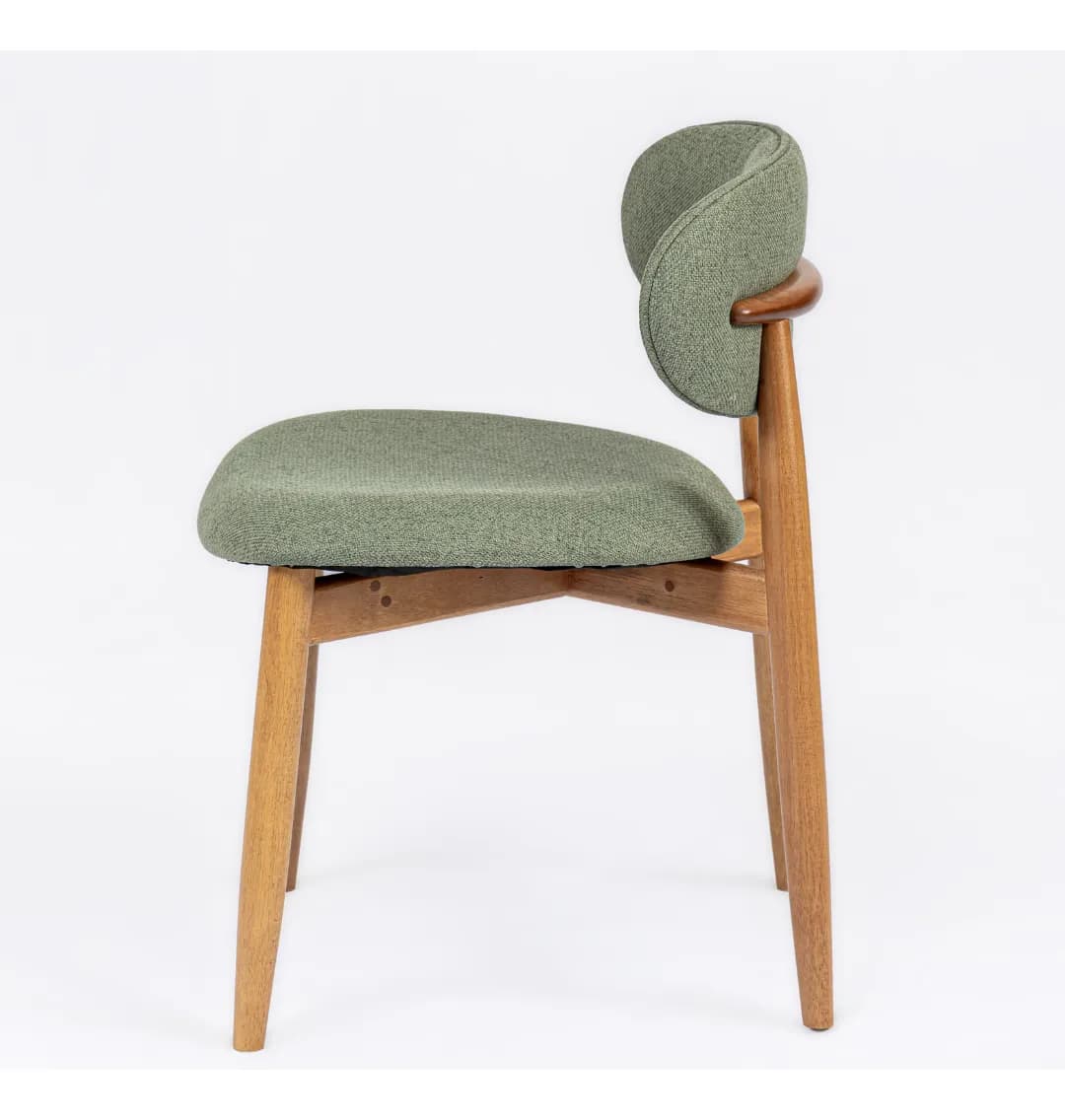 A side profile view of a modern dining chair. It features a gently curved, cushioned seat and backrest upholstered in a textured, light green fabric. The chair has a distinctive organic shape for its backrest. The frame is constructed from light-colored wood, with angled legs and supporting cross-braces visible beneath the seat. A small, curved wooden accent is integrated into the upper part of the backrest structure. — 3D model