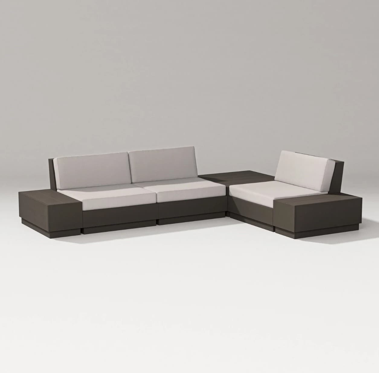 A modern sectional sofa composed of multiple modular units. The base and armrests are constructed from dark-colored material, forming a cohesive and blocky structure. The seating and back cushions are upholstered in a light, neutral fabric, providing a contrast to the darker frame. The configuration suggests an L-shaped arrangement, suitable for contemporary living spaces or outdoor patios. — 3D model