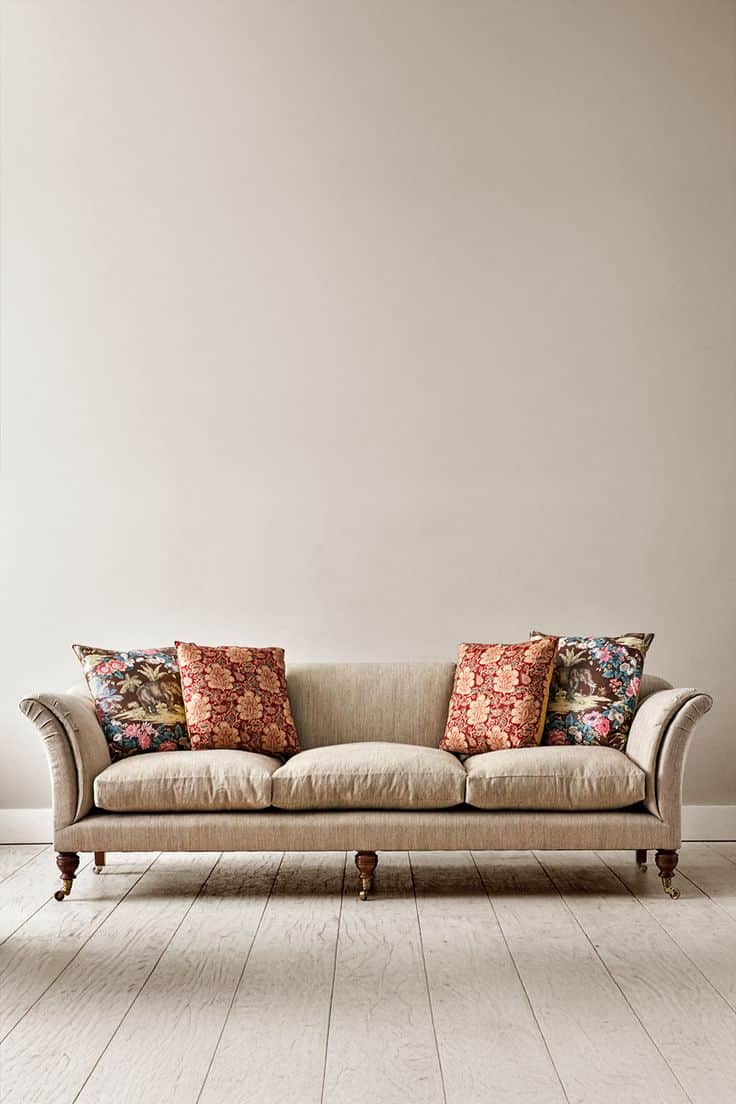 A traditional three-seater sofa upholstered in a neutral beige fabric, featuring classic rolled arms… — free GLTF 3D model