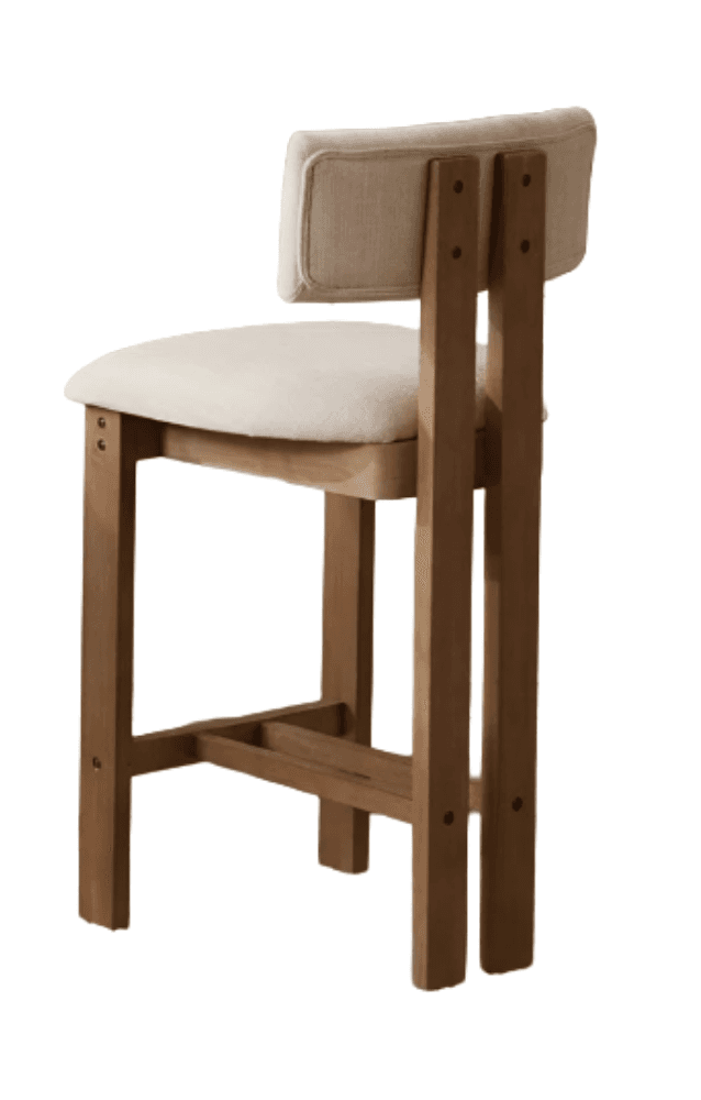 A contemporary bar stool featuring a sturdy light-toned wooden frame and upholstered seat and backrest. The frame consists of four straight legs joined by horizontal stretchers, forming a footrest. The seat and low backrest are padded and covered in a light, possibly cream or beige, fabric, providing comfort. The backrest is designed to float between two vertical wooden supports that extend from the rear legs, creating a clean, minimalist aesthetic. The overall construction appears robust and functional. — 3D model