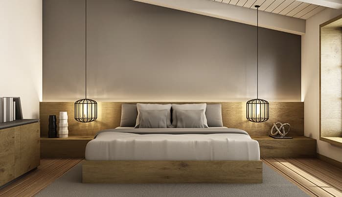 A modern platform bed system featuring a light wood finish. The design incorporates an extended headboard that acts as a back panel, flanked by integrated floating nightstands. Each nightstand is equipped with a black wire cage pendant lamp suspended above it. The bed itself has a minimalist platform base and is dressed with grey and white bedding and pillows. — 3D model