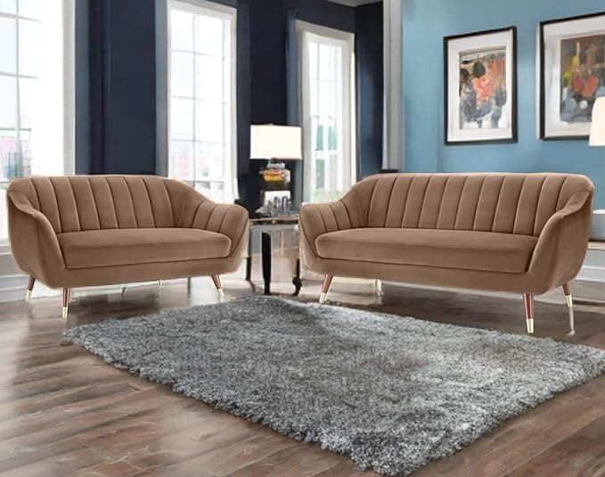 A two-seater loveseat featuring a contemporary design with a curved silhouette and vertical channel tufting on the backrest and inner arms. It is upholstered in a smooth, brown velvet fabric and stands on four slender, tapered wooden legs, each finished with a brass cap. — 3D model