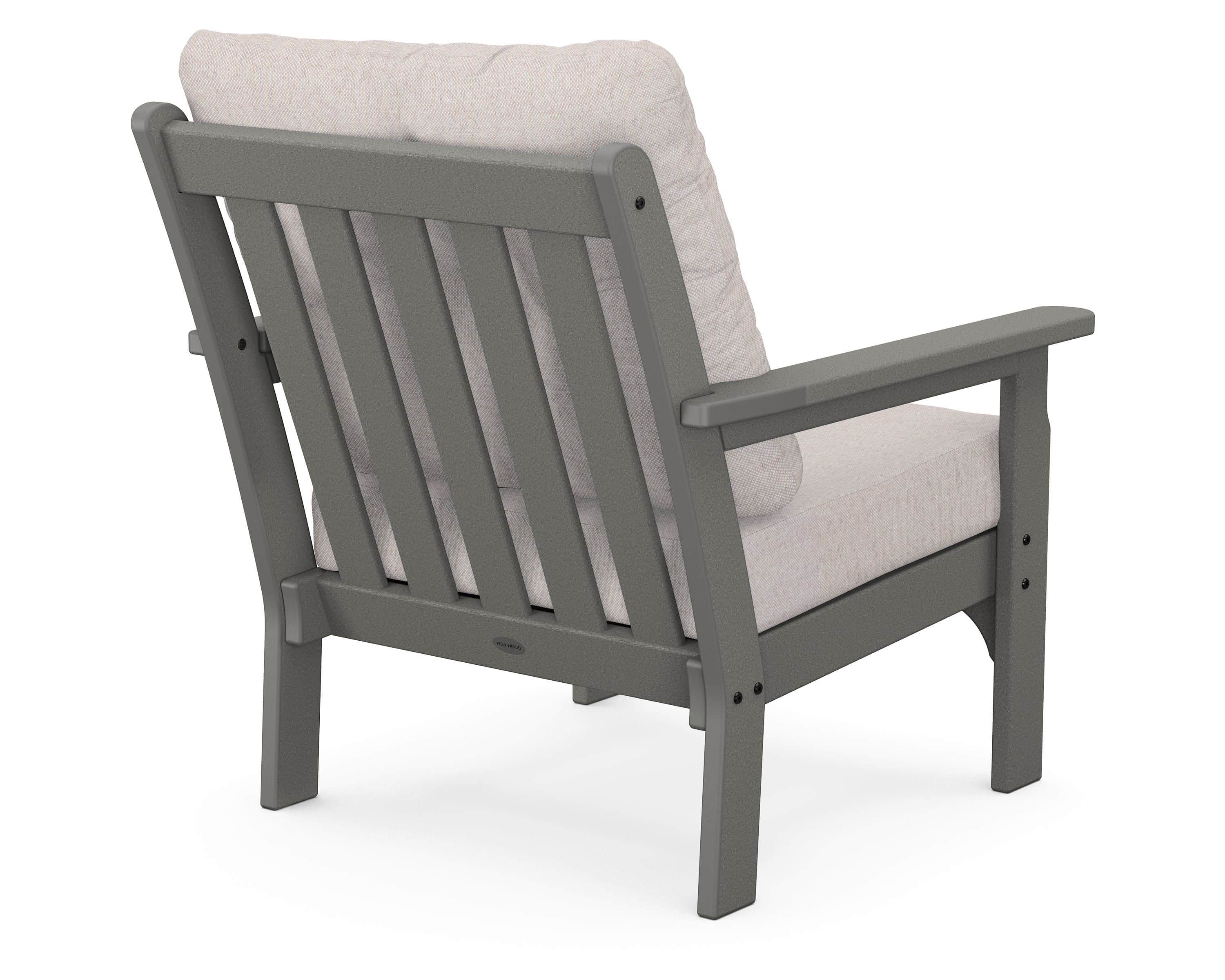 A gray outdoor armchair with a slatted backrest and upholstered seat and back cushions. The armchair… — 3D model