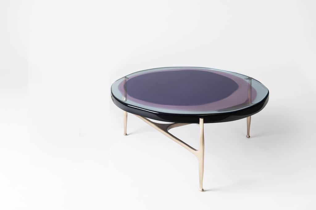 A round coffee table featuring a clear glass top with an iridescent finish that displays shifting co… — 3D model