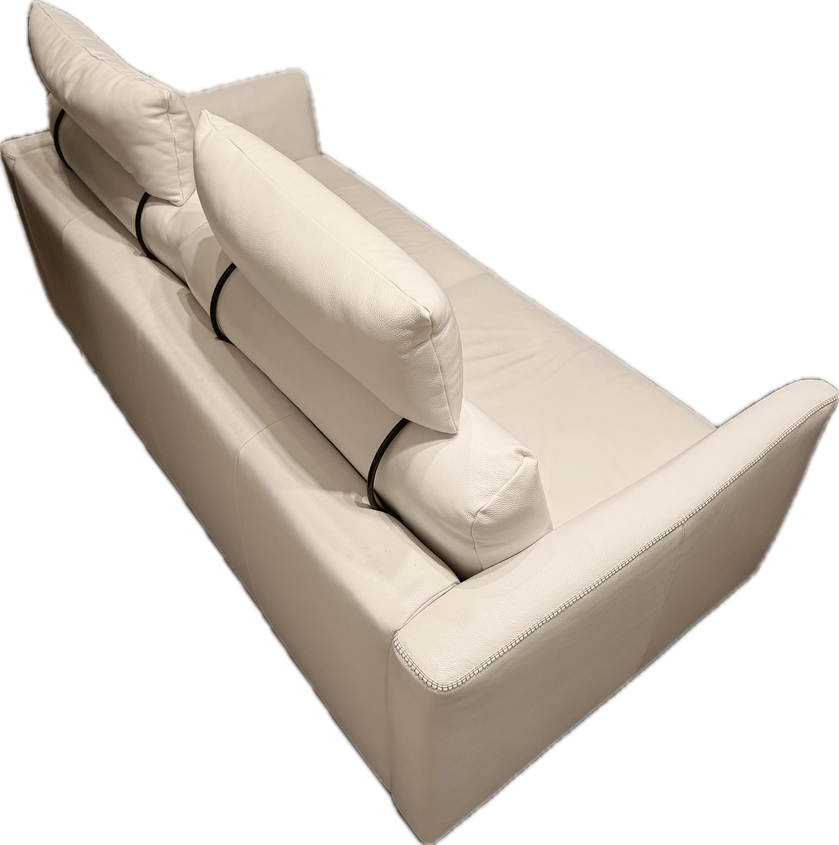 A modern sofa upholstered in white or off-white leather, featuring a minimalist design with a low profile. It has integrated, wide armrests and a deep seat. The backrest is formed by multiple loose cushions, which are secured by visible black straps. The upholstery exhibits subtle texture and detailed stitching along the edges, suggesting a contemporary and sophisticated aesthetic. — 3D model