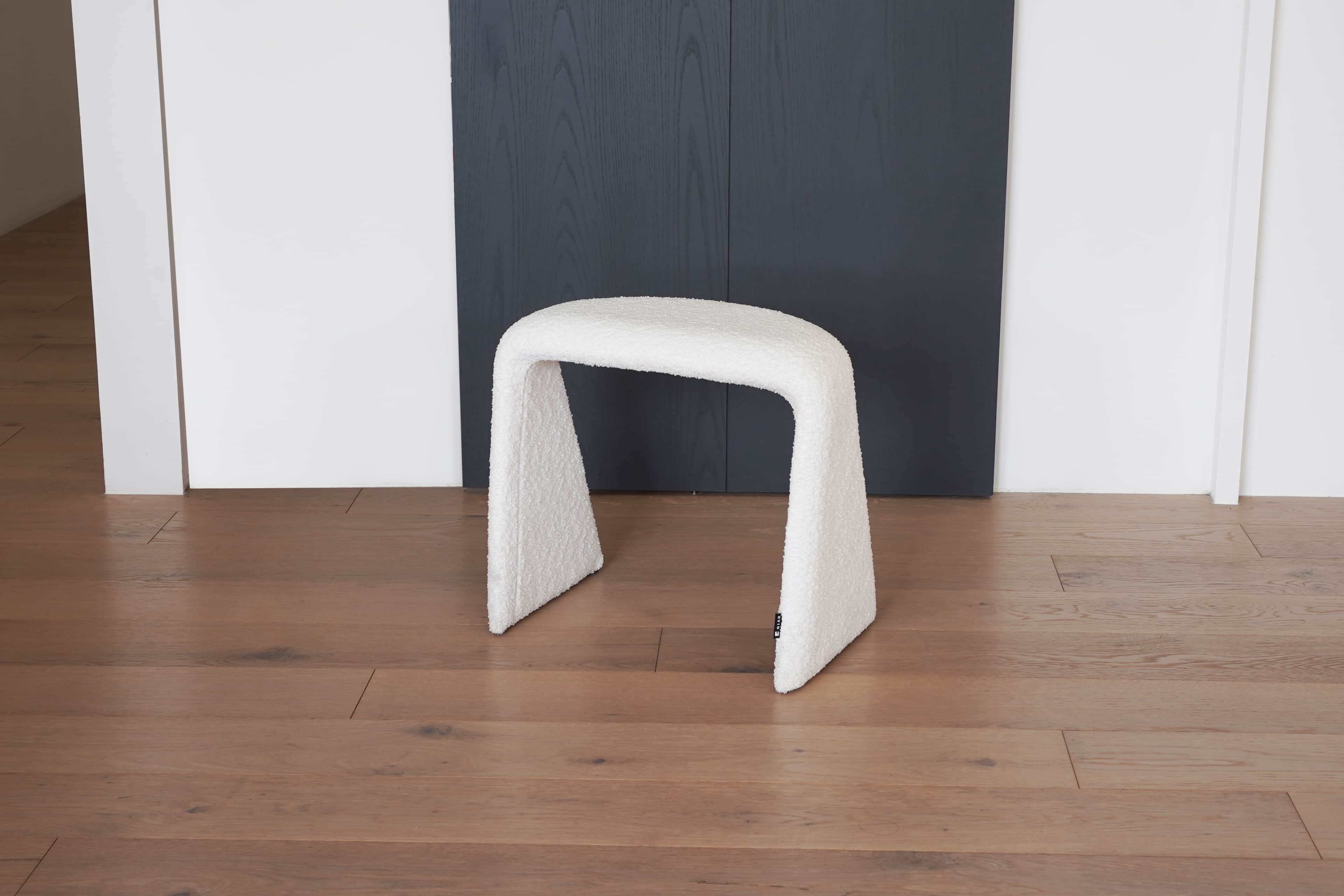 A white, textured stool with a unique U-shaped base. The stool appears to be upholstered in a boucle… — 3D model
