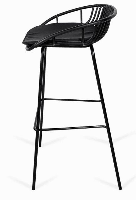 A contemporary bar stool featuring a black powder-coated metal wireframe bucket seat and backrest, paired with a fitted black padded seat cushion. The stool stands on four slender, tapered metal legs with integrated footrests, all finished in a matching matte black. — 3D model