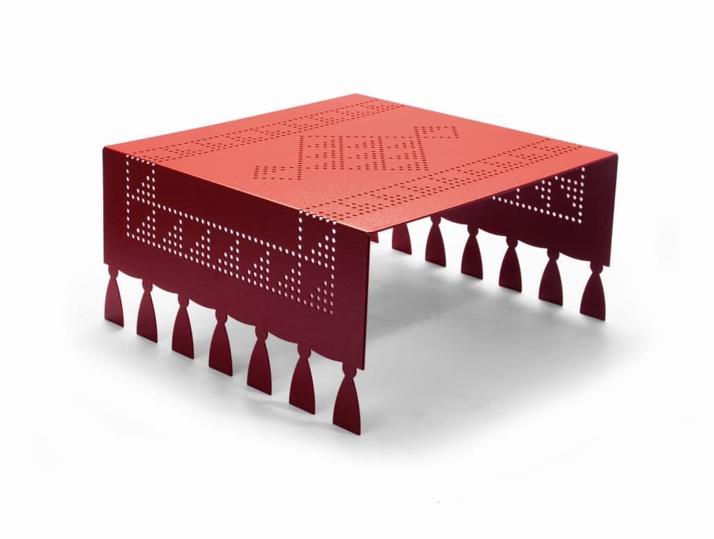 A low, rectangular coffee table constructed from red perforated metal. It features intricate geometric patterns on its top and sides, and its edges are cut into decorative tassel shapes which also serve as its support structure. — 3D model
