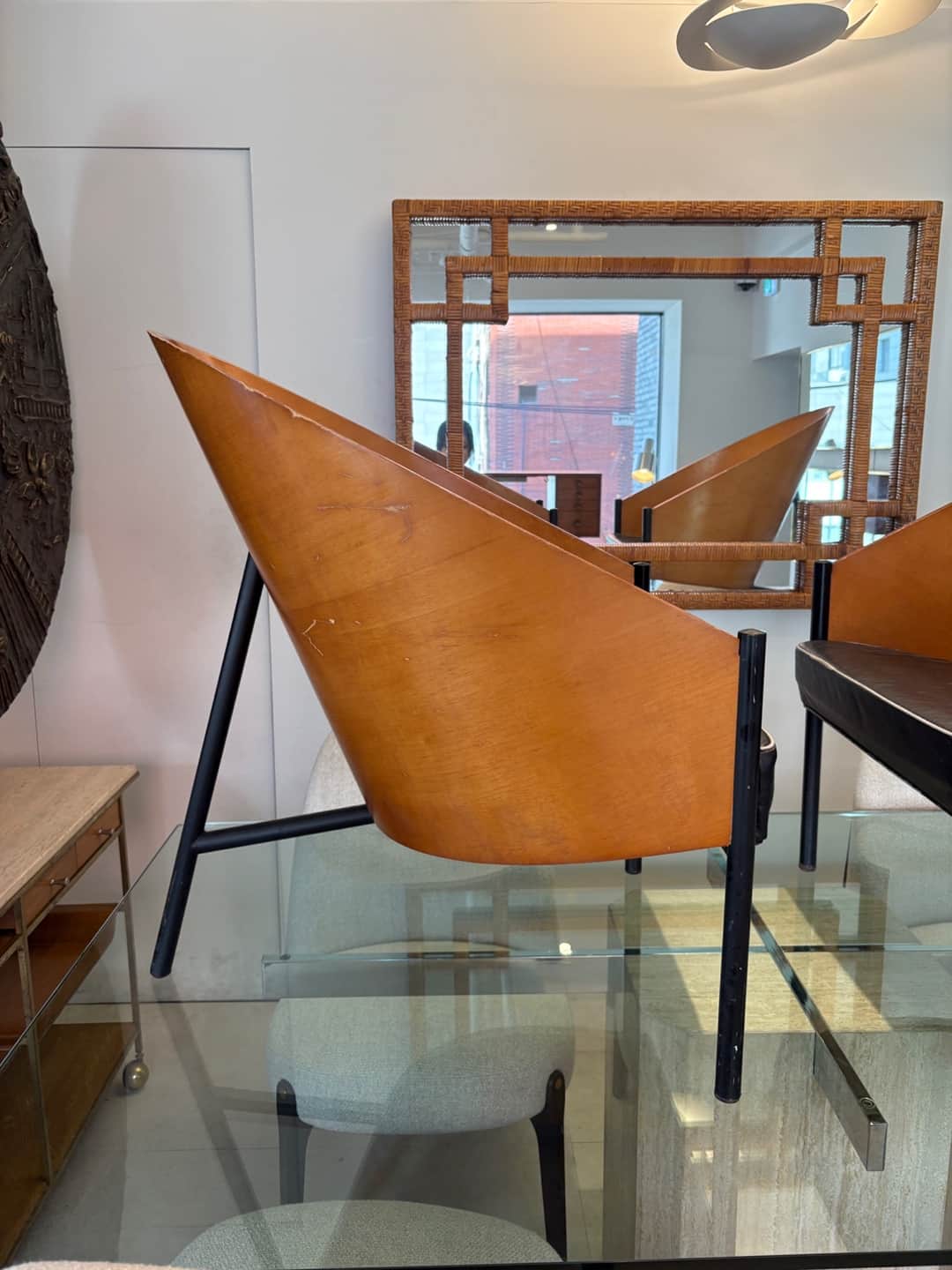 A striking lounge chair featuring a distinctive conical shell crafted from light brown bent plywood,… — 3D model