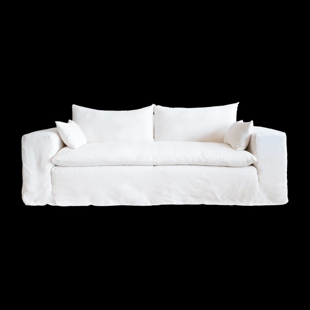 A white slipcovered sofa with two seat cushions and two back cushions. Two small accent pillows are placed on either end of the sofa. The sofa has a relaxed, casual style with a skirted base. — 3D model