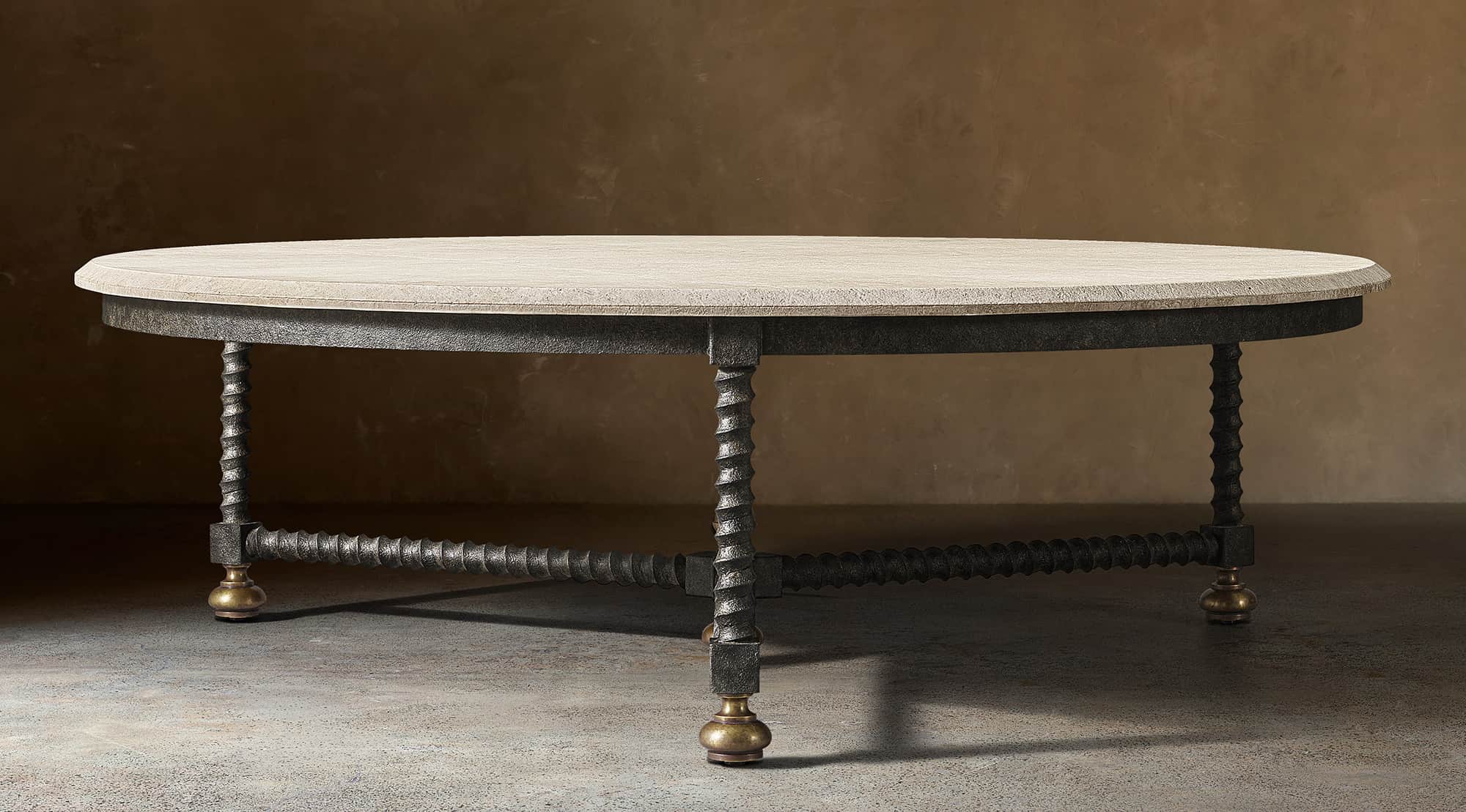 An oval coffee table featuring a light-colored, rough-hewn stone tabletop. The base consists of a da… — 3D model