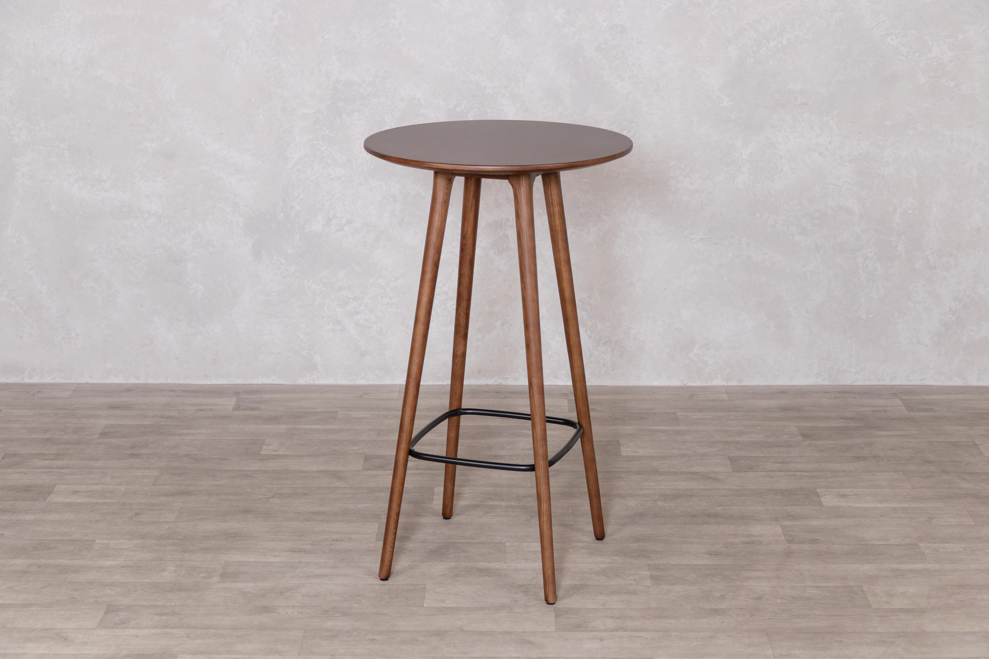 A tall, round bar table featuring a dark walnut-finished tabletop supported by three splayed wooden legs, which are reinforced and connected by a black metal ring footrest. — 3D model