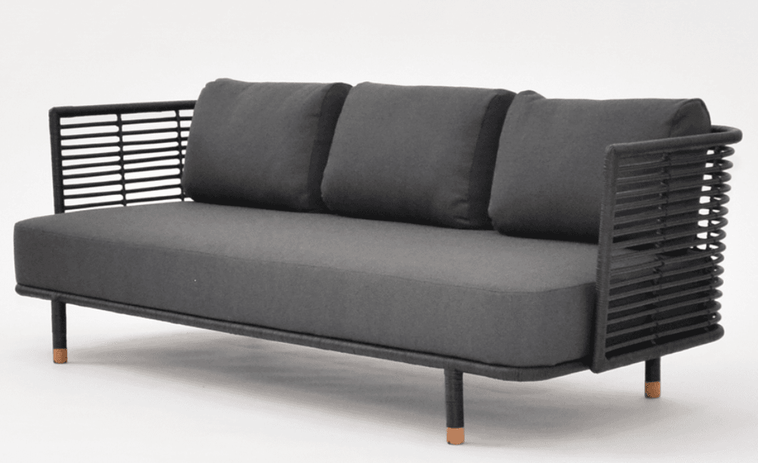 A three-seater sofa with a modern design. The frame is constructed from dark material, possibly metal or treated wood, and is intricately woven with black cord or rope on the sides and backrest, creating a slatted effect. The seat and back cushions are upholstered in a dark grey, textured fabric. It has thin, dark legs with visible wooden accents at the very bottom. — 3D model