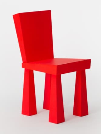 A contemporary, armless side chair featuring a striking monochromatic red finish. Its design is characterized by thick, geometric forms including a flat rectangular seat, a slightly angled backrest, and four robust, tapered legs that splay outwards from the seat. — 3D model