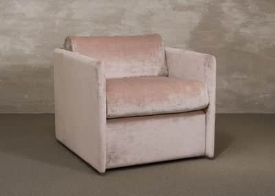 A contemporary armchair with a boxy silhouette, upholstered in a soft, textured pink fabric. It feat… — 3D model