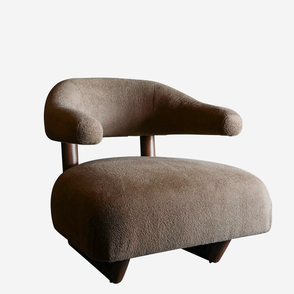 A modern armchair with a rounded, upholstered seat and back. The armrests are integrated into the backrest and curve forward. The chair has a visible wooden frame structure supporting the upholstery, with two vertical wooden posts supporting the backrest and a wooden base with angled legs. — 3D model