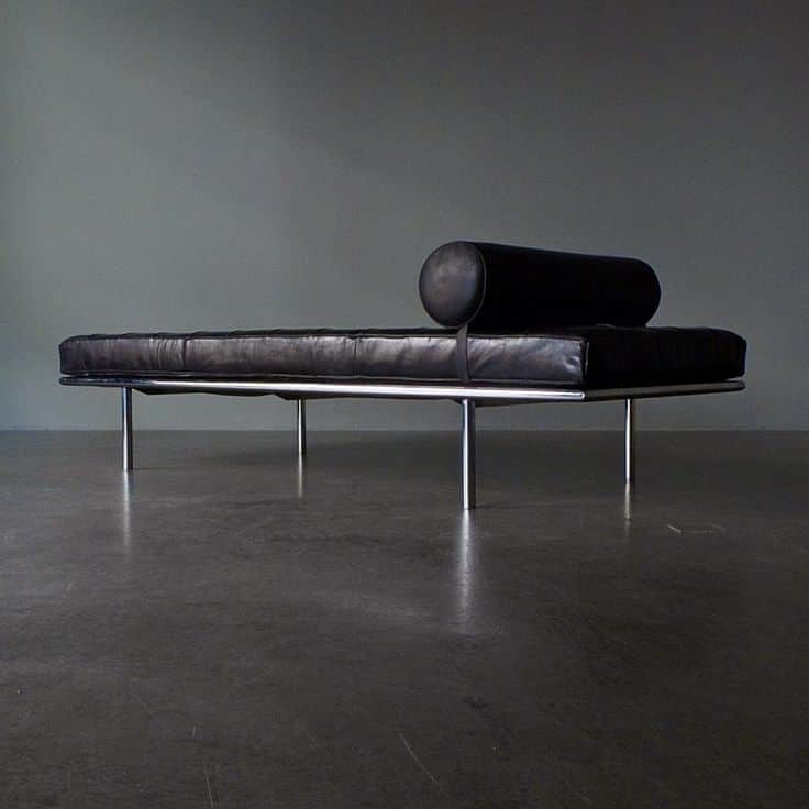 A tufted black leather daybed with a cylindrical bolster pillow. The daybed has a sleek, modern desi… — 3D model