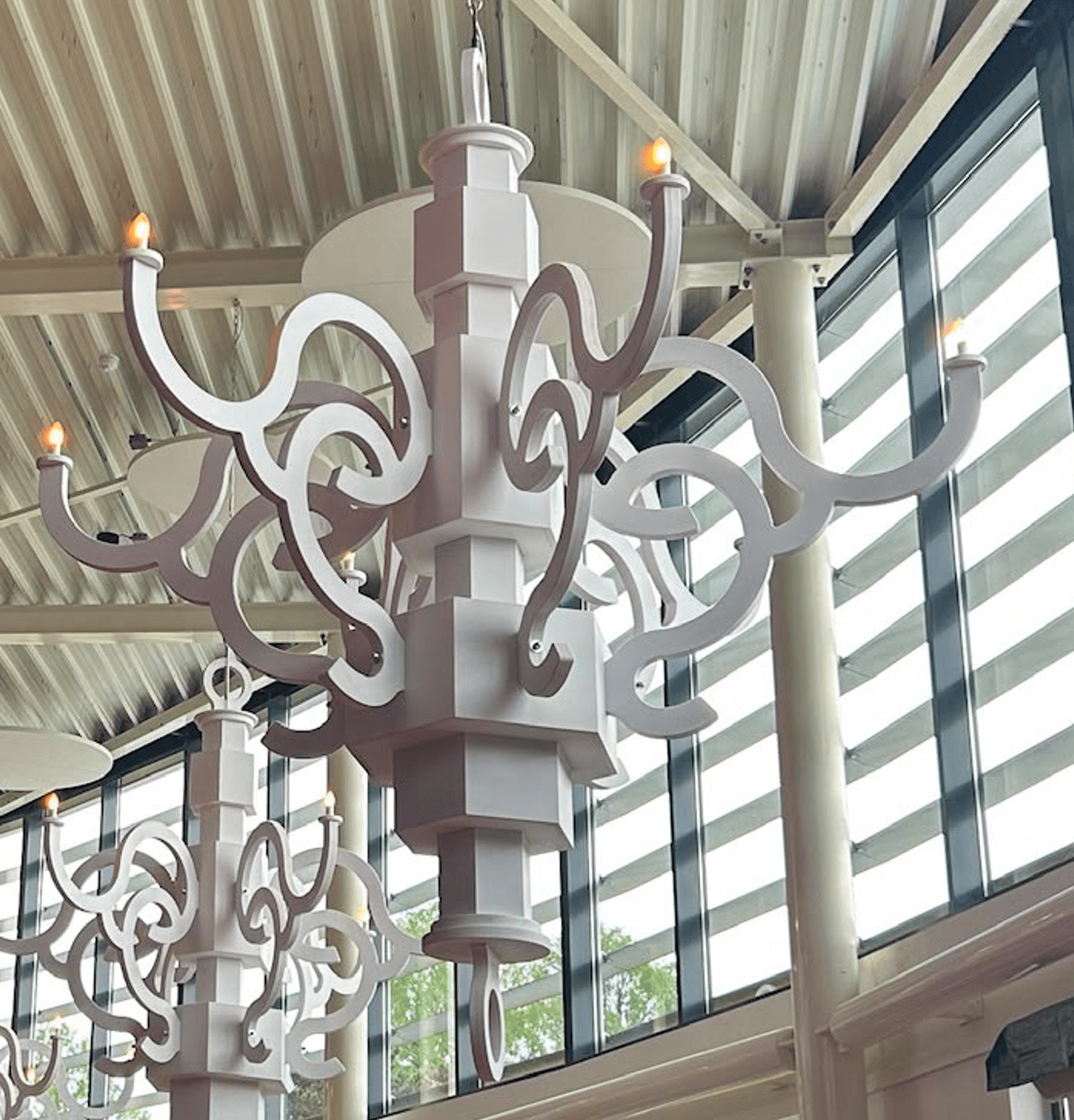 A white, sculptural coat rack with a central column and multiple undulating arms, each tipped with a round, orange-brown knob, designed for hanging items. — 3D model