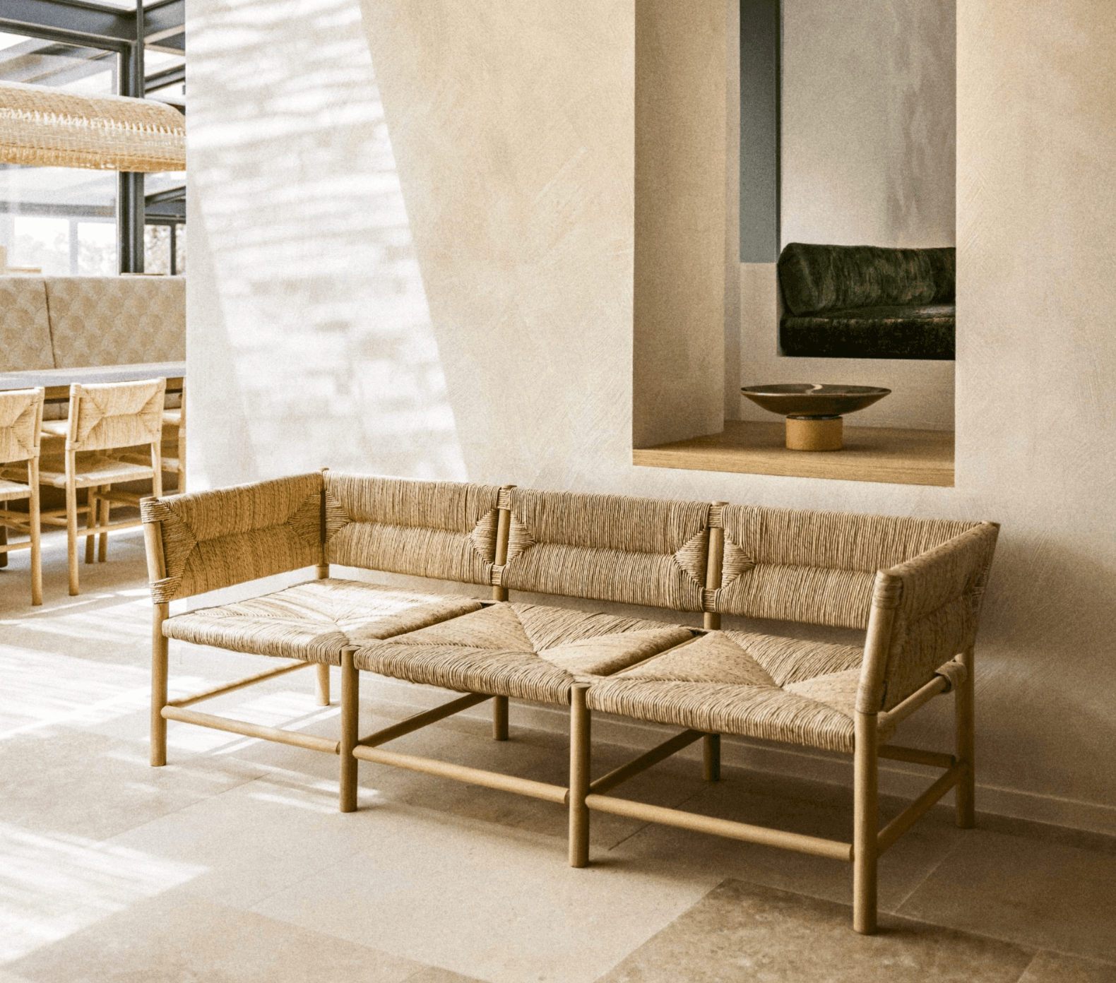 A long three-seater bench featuring a light wood frame and intricately woven natural fiber for both the seat and backrest sections. The design is minimalist and showcases detailed craftsmanship through its woven patterns. — 3D model