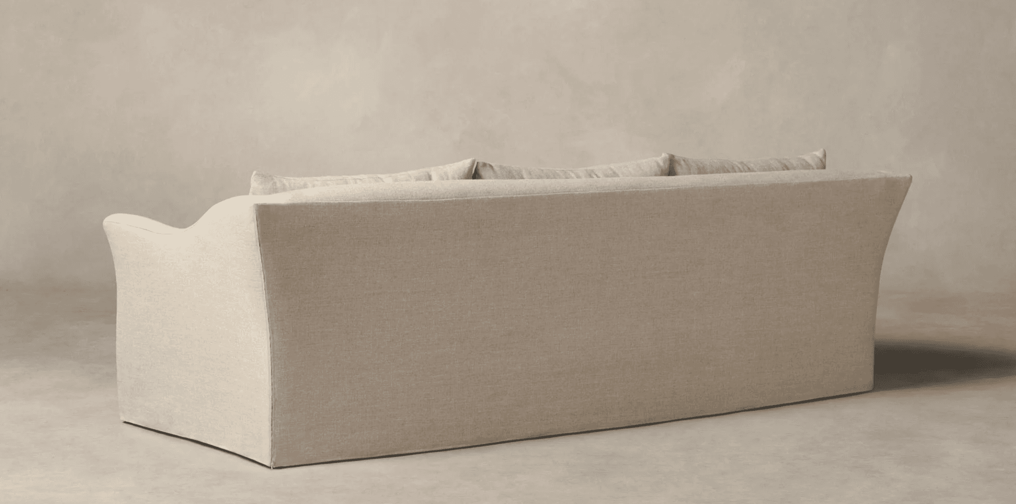 A three-seater sofa, viewed from the rear and side. The sofa features a loose slipcover construction… — 3D model