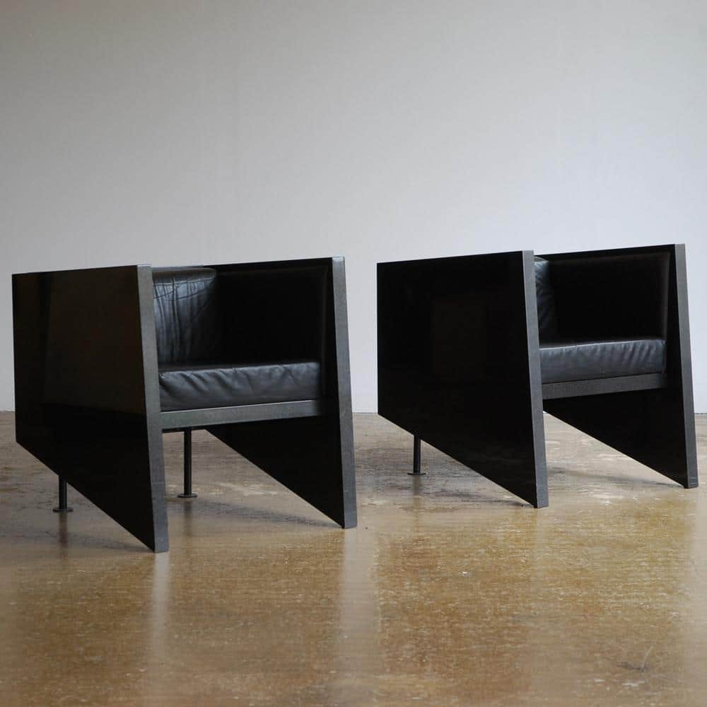 A pair of modern armchairs with a distinctive geometric design, featuring angular dark-stained wood… — 3D model