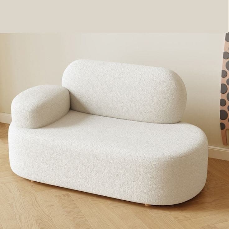 An off-white, sculptural single-seater chaise lounge chair with soft, rounded edges, upholstered in a textured boucle fabric, featuring an integrated backrest and a single armrest. — 3D model