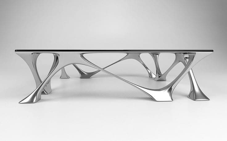 A modern coffee table featuring a rectangular black glass top supported by a highly sculptural, polished silver-tone metal base with organic, branching leg structures. — 3D model