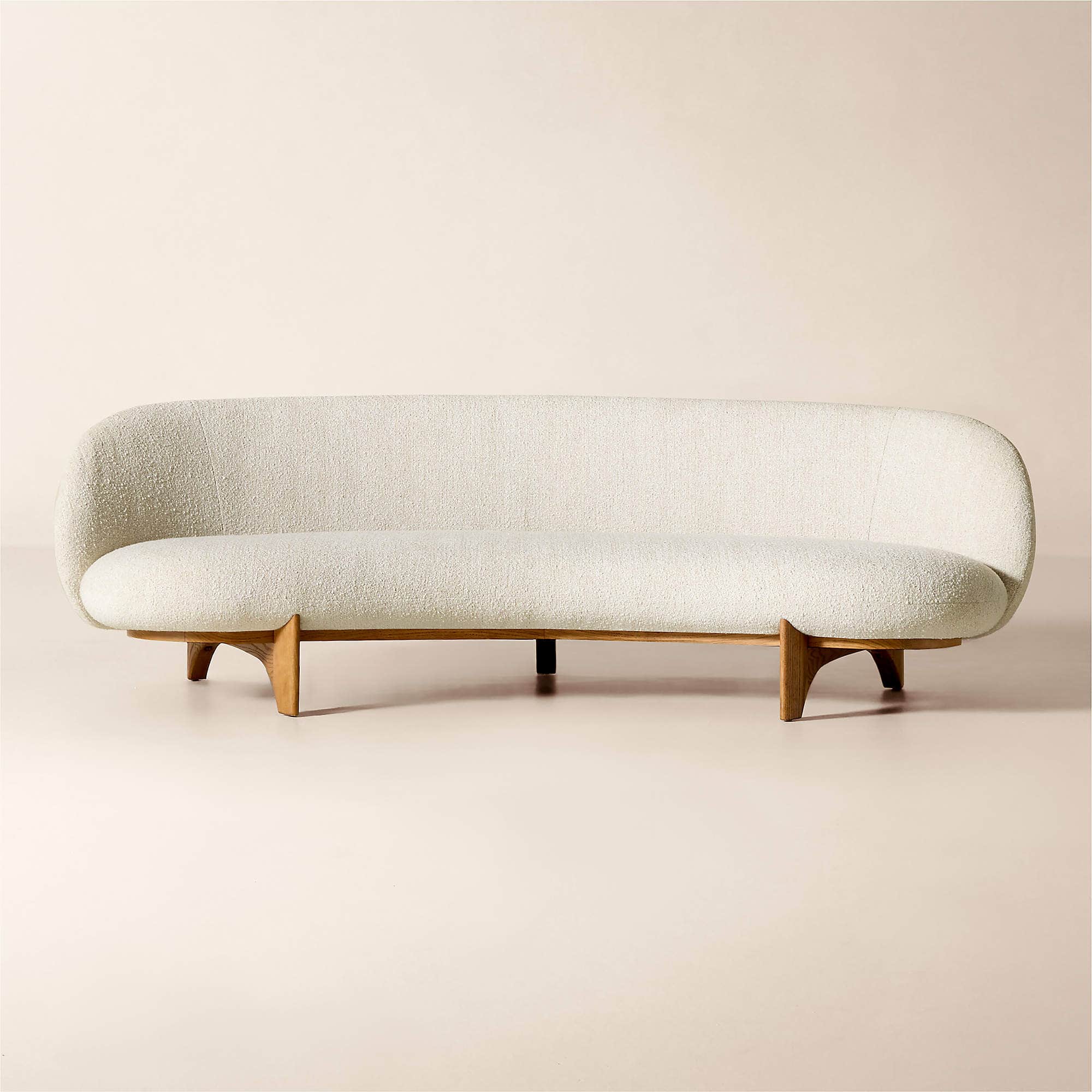 A mid-century modern inspired sofa with a curved back and seat, upholstered in a textured cream fabr… — 3D model