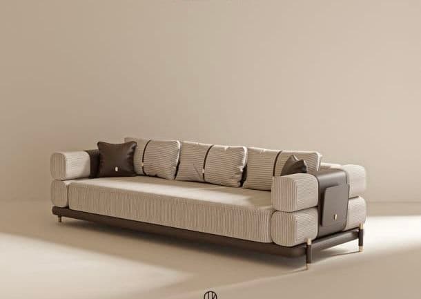 A contemporary upholstered sofa featuring a long, rectangular form. The main upholstery is a light beige fabric with fine vertical stripes, contrasted by dark brown leather or faux leather accents on the base, armrests, and throw pillows. The backrest is composed of multiple individual vertical cushions, some secured by dark brown straps. The armrests are structured with stacked rectangular upholstered modules, accented with dark brown panels. The sofa is supported by subtle, short metallic legs in a brass finish. — 3D model