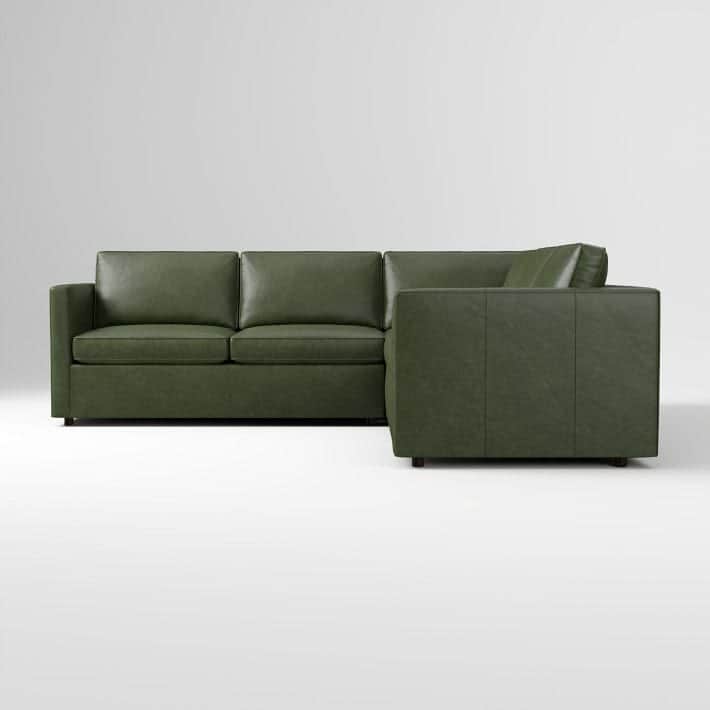 An L-shaped sectional sofa upholstered in a rich green leather or faux leather, featuring a contempo… — 3D model