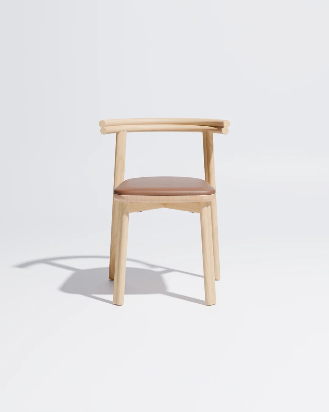 A minimalist chair made from light-colored wood featuring a gently curved backrest that integrates into armrests, and a padded brown leatherette seat. — 3D model