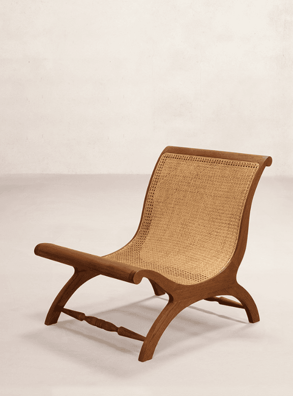 A low-slung, armless lounge chair featuring a dark stained wooden frame and natural cane webbing for both the seat and backrest. The frame exhibits curved profiles, contributing to a relaxed aesthetic. — 3D model