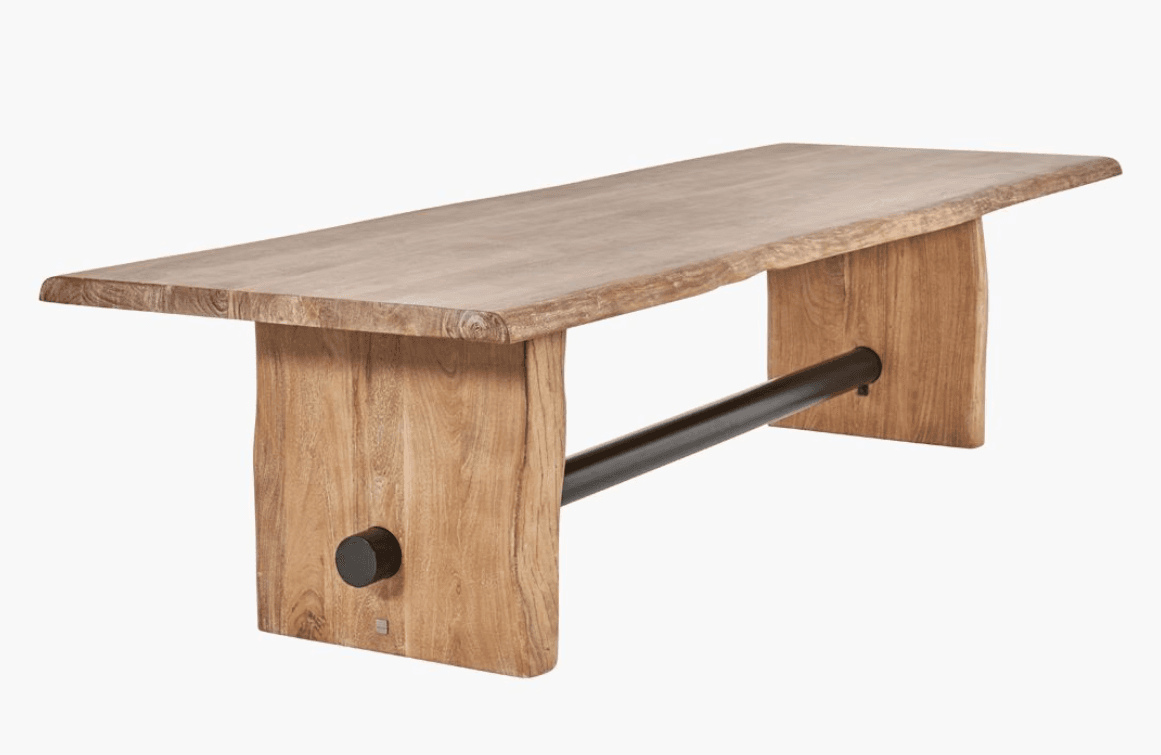 A live-edge dining table with a thick, solid wood top and two solid wood block legs. A dark metal rod runs horizontally between the legs for structural support and aesthetic contrast. The wood exhibits a natural grain pattern and a light, natural finish. One leg has a circular black accent piece near its base. — 3D model