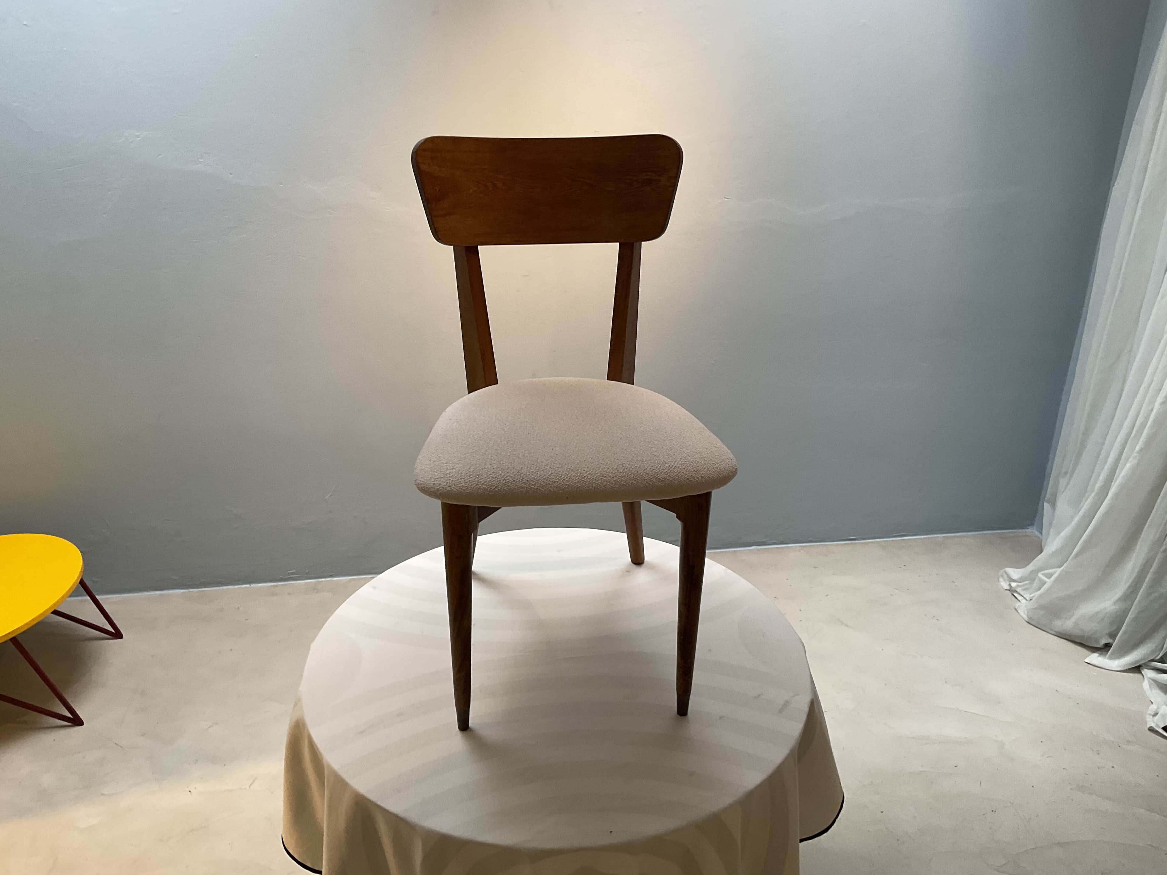 A wooden chair with a cushioned seat, positioned on a round table covered with a tablecloth. The cha… — 3D model
