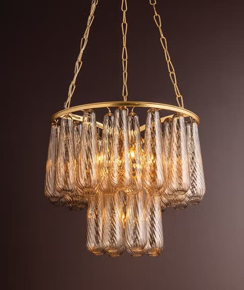 A contemporary tiered chandelier featuring a gold-finished metal frame and numerous textured, amber-toned glass shades. The fixture is suspended by a delicate chain from a matching ceiling canopy, with internal light sources illuminating the glass elements. — 3D model