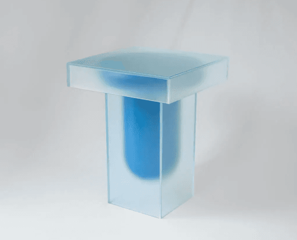 A modern side table with a square top and a rectangular pedestal base. The table features a frosted glass exterior and a translucent blue interior. — 3D model