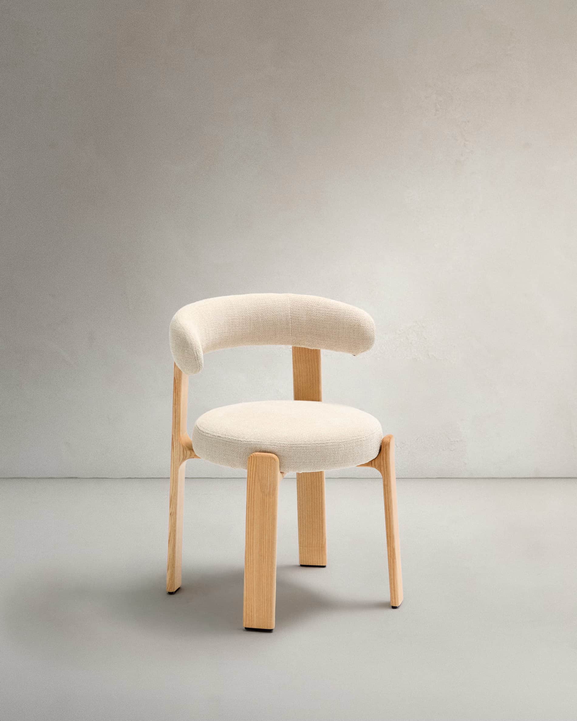 A contemporary armchair featuring a light wood frame and cream-colored upholstered seat and backrest… — free OBJ 3D model