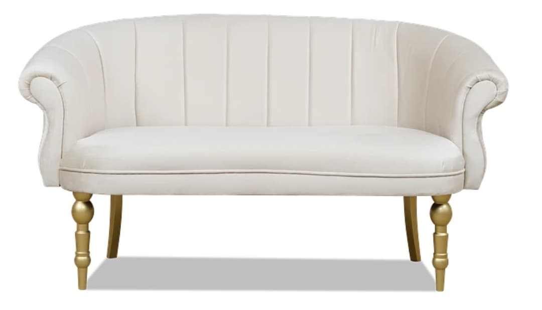 A stylish small loveseat or settee featuring a gracefully curved backrest with vertical channel tufting, rolled armrests, and an upholstered seat. The piece is supported by four golden-finished, turned wooden legs, with the front legs exhibiting a more elaborate design compared to the simpler tapered rear legs. The upholstery appears to be a soft, light-colored fabric, possibly velvet or a similar plush material. — 3D model