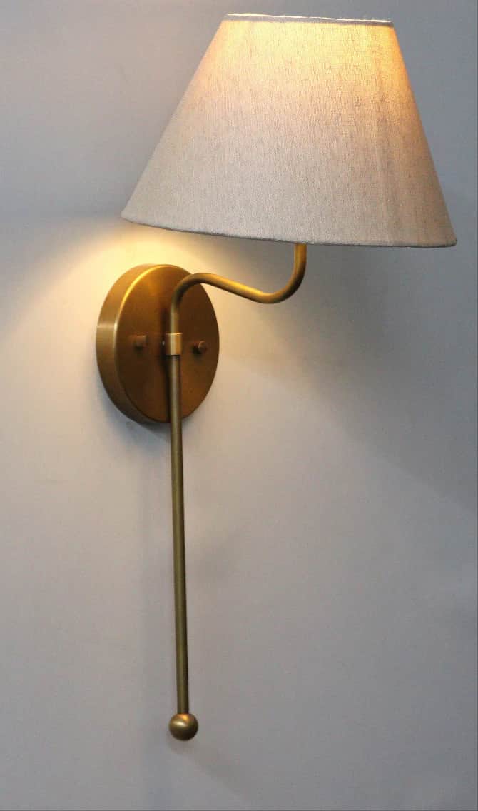 A wall-mounted lamp with a conical fabric shade and a brass-finished metal arm and base. A pull chai… — 3D model