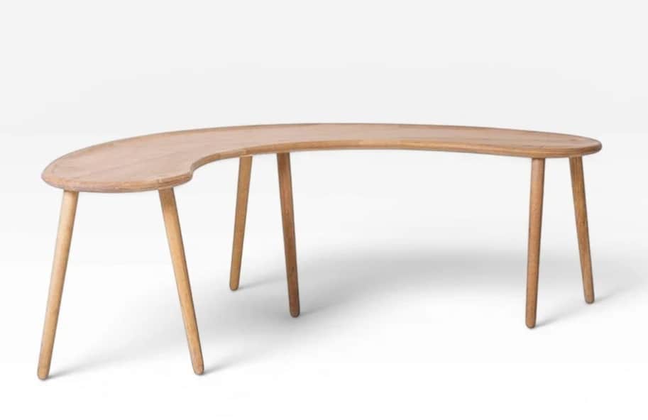 A light-toned wooden coffee table featuring a distinct crescent or bean-shaped top supported by mult… — 3D model