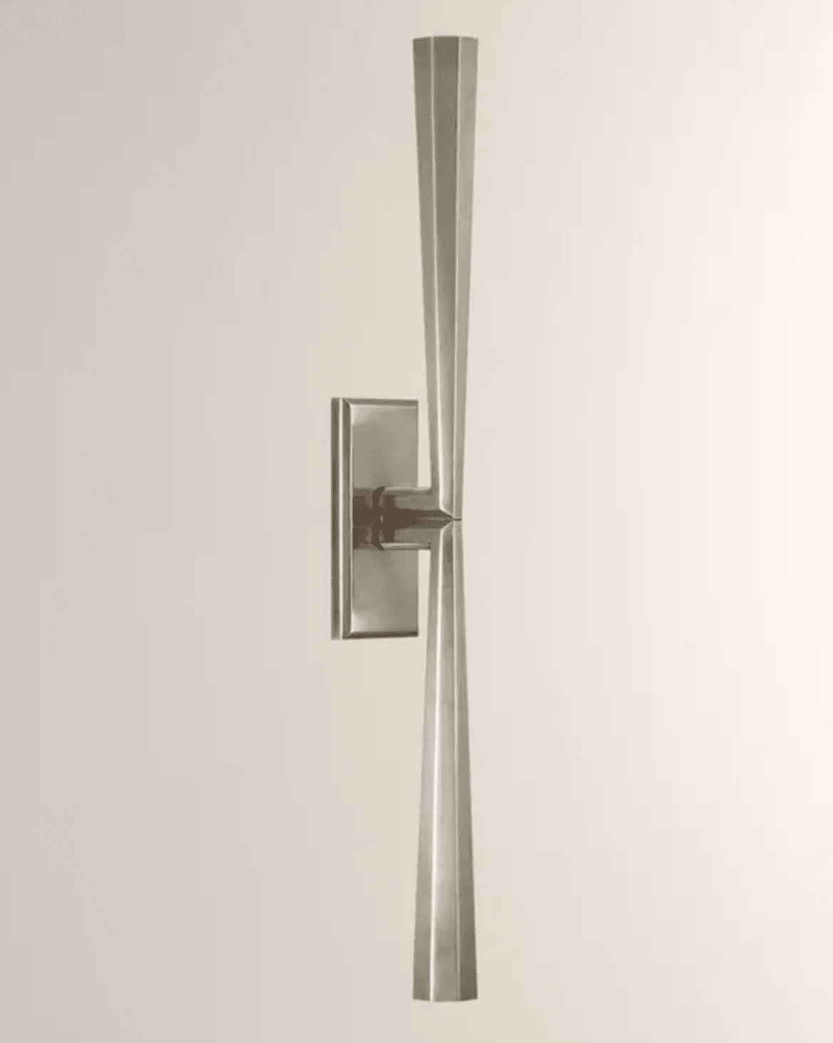 A contemporary wall sconce featuring a rectangular backplate and two symmetrical, elongated, tapering arms that extend vertically. The arms have a faceted, geometric profile, giving the fixture a sculptural and architectural appearance. It is made from a brushed or satin-finished silver-toned metal. — 3D model