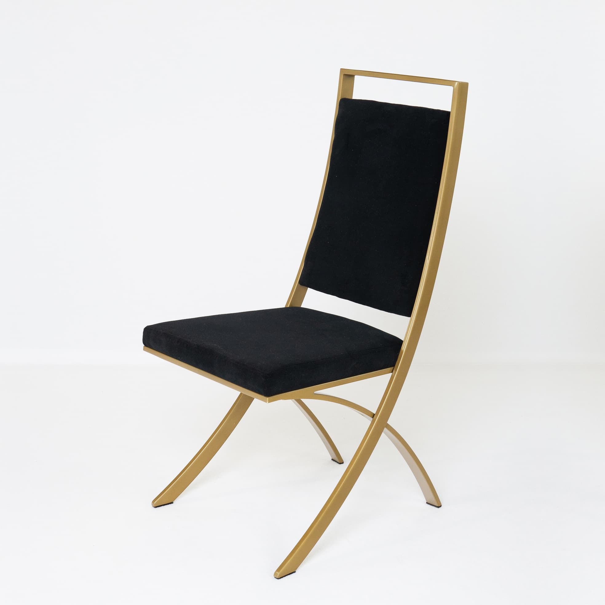 A contemporary dining chair featuring a striking gold-finished metal frame and black upholstered seat and backrest. The frame exhibits elegantly curved lines, creating a minimalist yet sophisticated silhouette. The seat and backrest are rectangular, providing comfortable support, with the backrest extending slightly above the upholstered section to form an open, rectangular top. The overall design suggests a modern aesthetic suitable for dining or accent seating. — 3D model