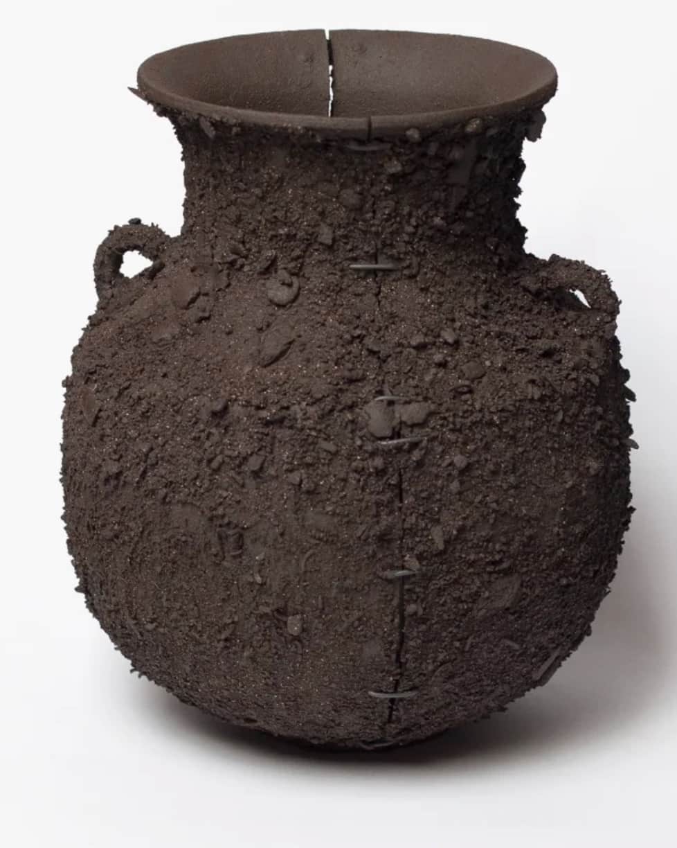 A dark, heavily textured ceramic urn featuring a globular body, a wide, flared rim, and a single vis… — 3D model