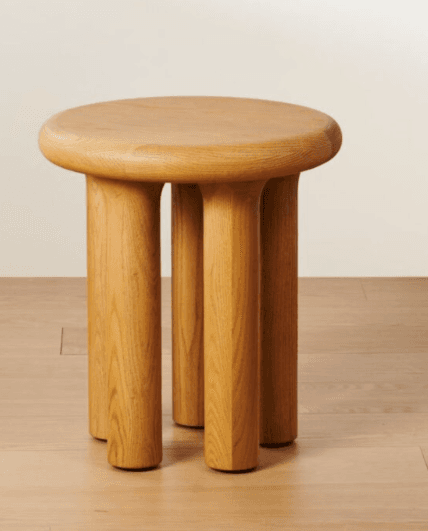 A wooden end table with a round, slightly domed top and four cylindrical legs that taper slightly towards the base. The legs are connected directly to the underside of the tabletop. — 3D model