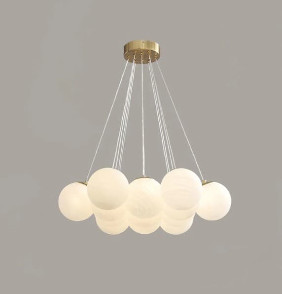 A modern multi-light chandelier featuring a circular brass canopy from which multiple white frosted glass globes are suspended at varying heights by thin wires. The globes appear to be internally illuminated, suggesting a soft, diffused light output. — 3D model