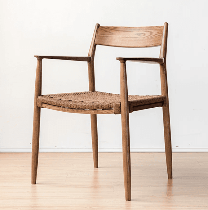 A Scandinavian-style armchair featuring a solid wooden frame with a curved backrest and integrated armrests. The seat is constructed from a natural woven material, likely paper cord, providing a textured surface. The chair has four tapered legs and a minimalist aesthetic. — 3D model